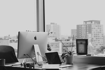 mac computer in an office facing the city